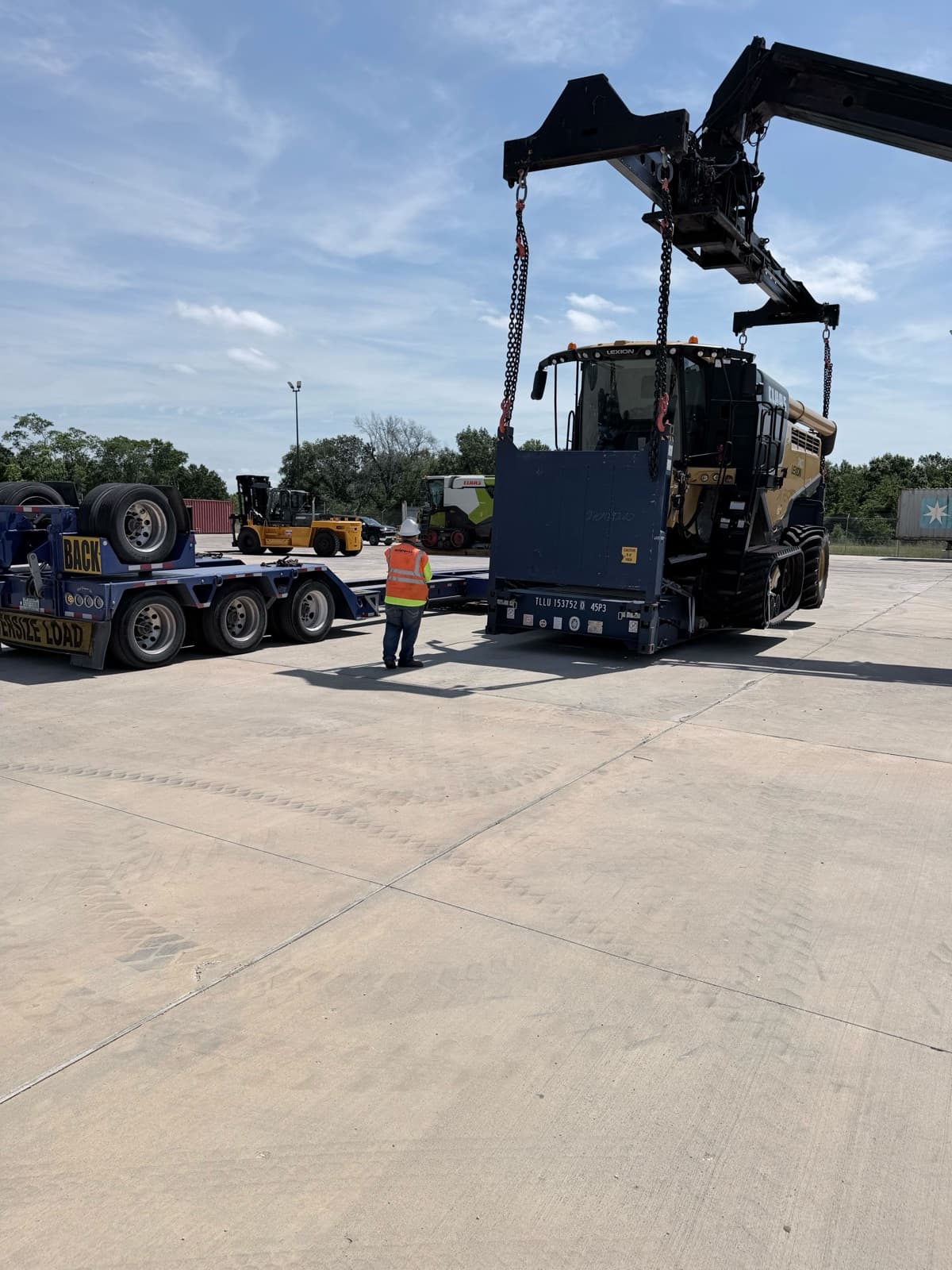 Ground crew in high-vis directing the reach stacker into position