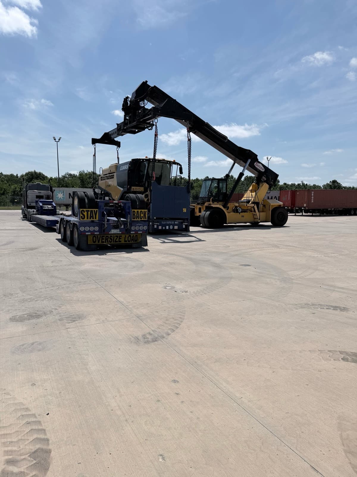 Harvester picked up on chains and held clear of the trailer deck