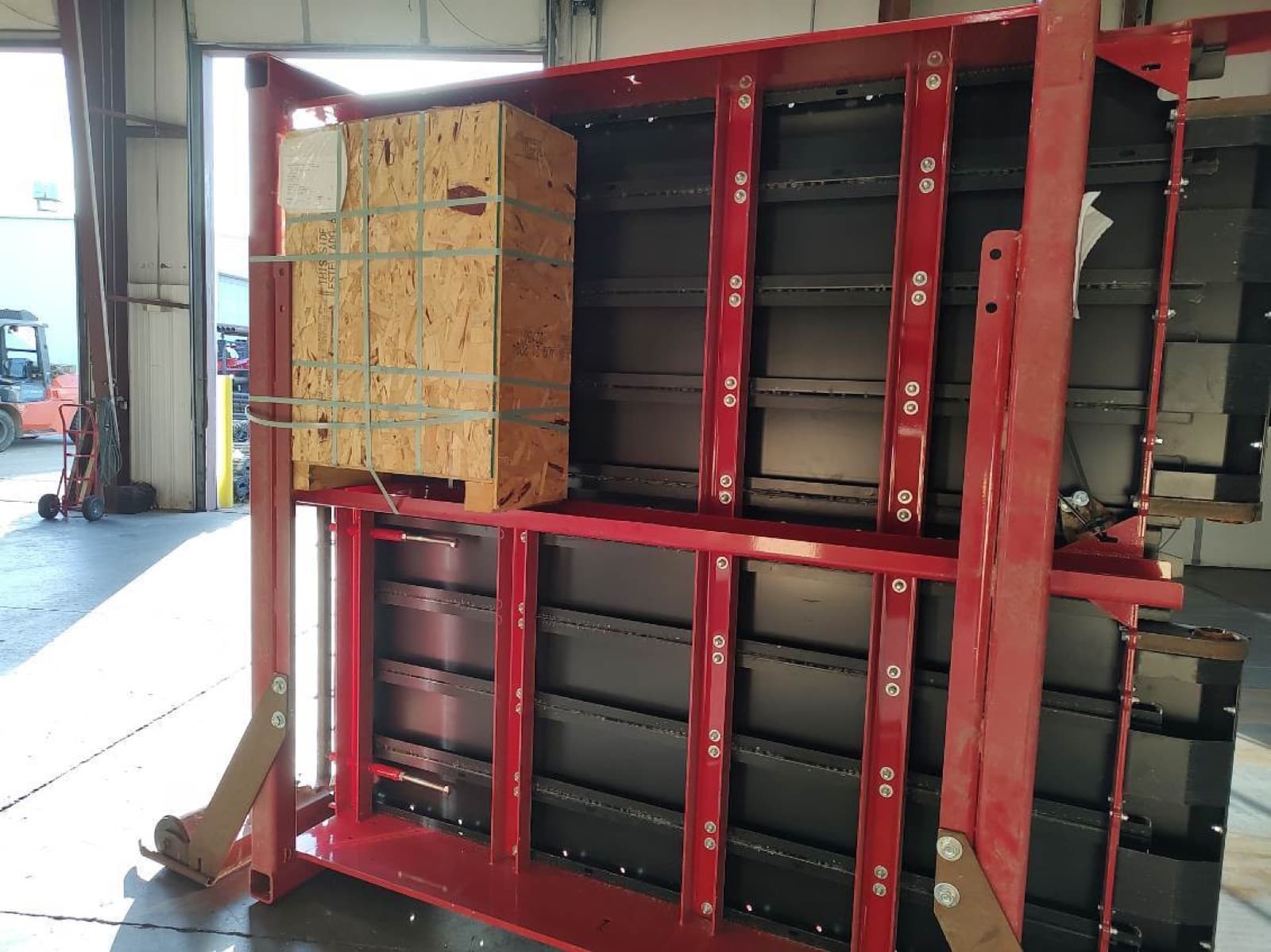 Panel racks and a finished plywood crate staged together on the shop floor