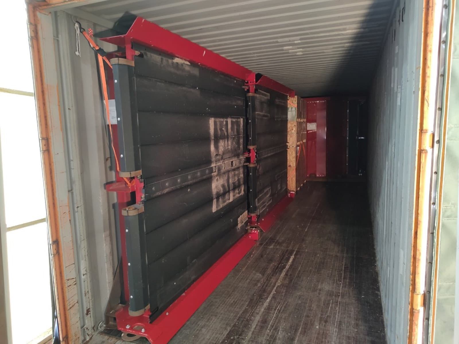 Panel frame braced against the container wall as loading continues
