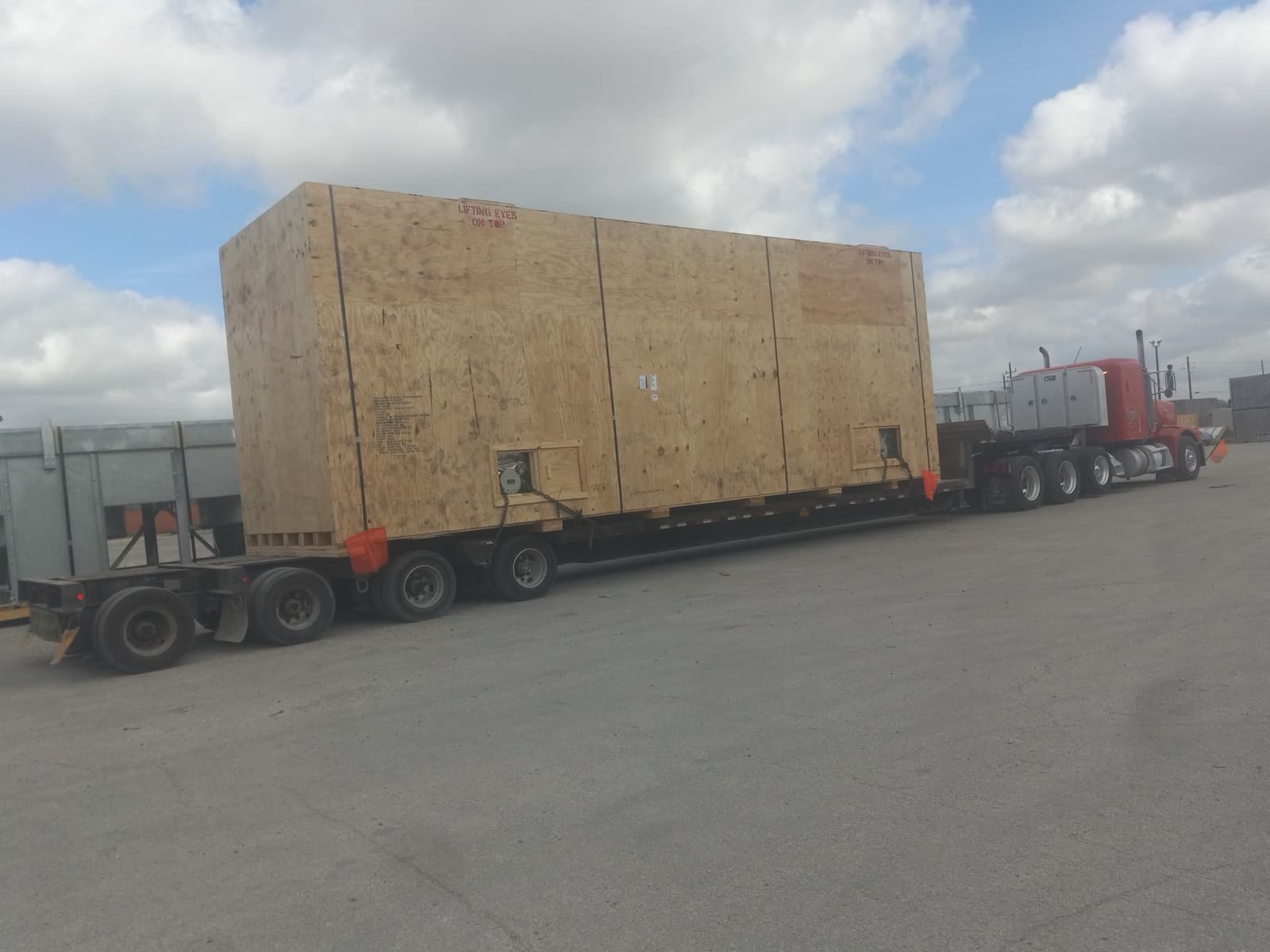 Crate loaded and chained on a spread-axle flatbed for the road move