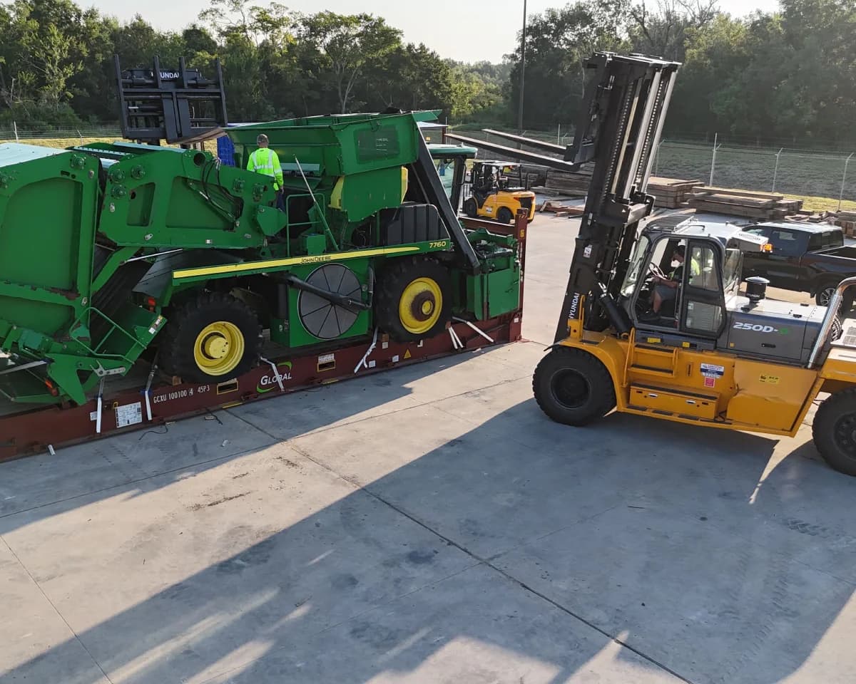 A combine and a wheel loader staged together in the yard.