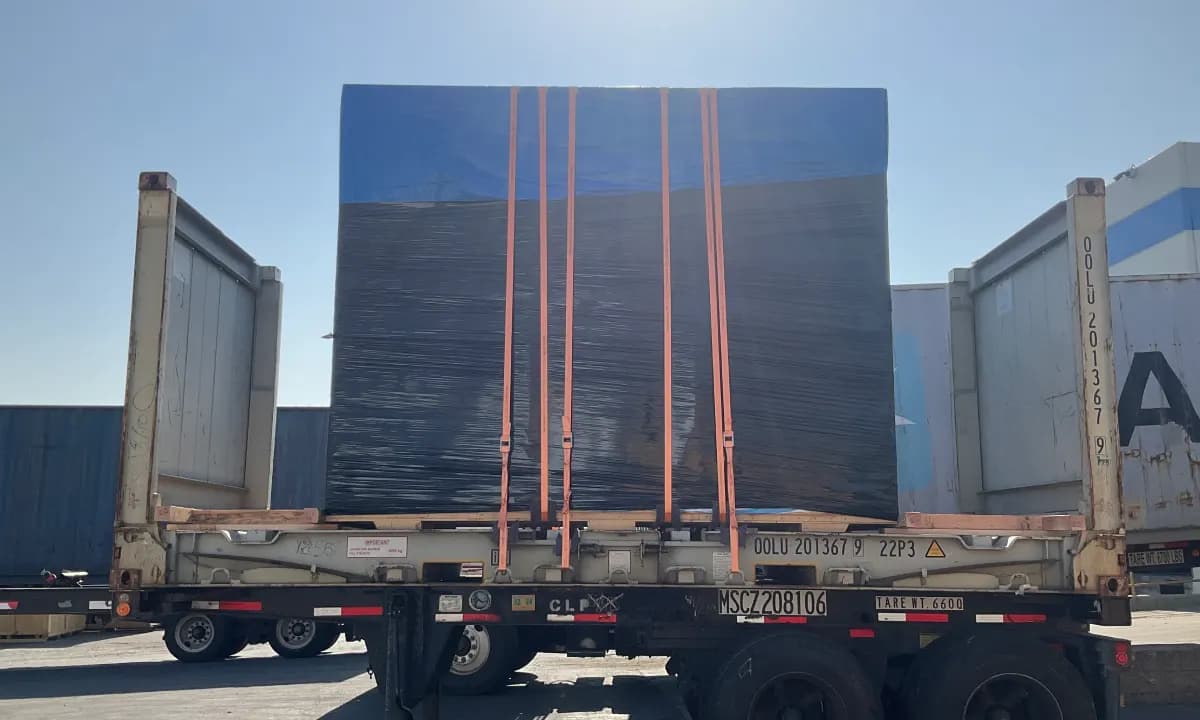 A sheeted load strapped to a flat rack at the terminal.