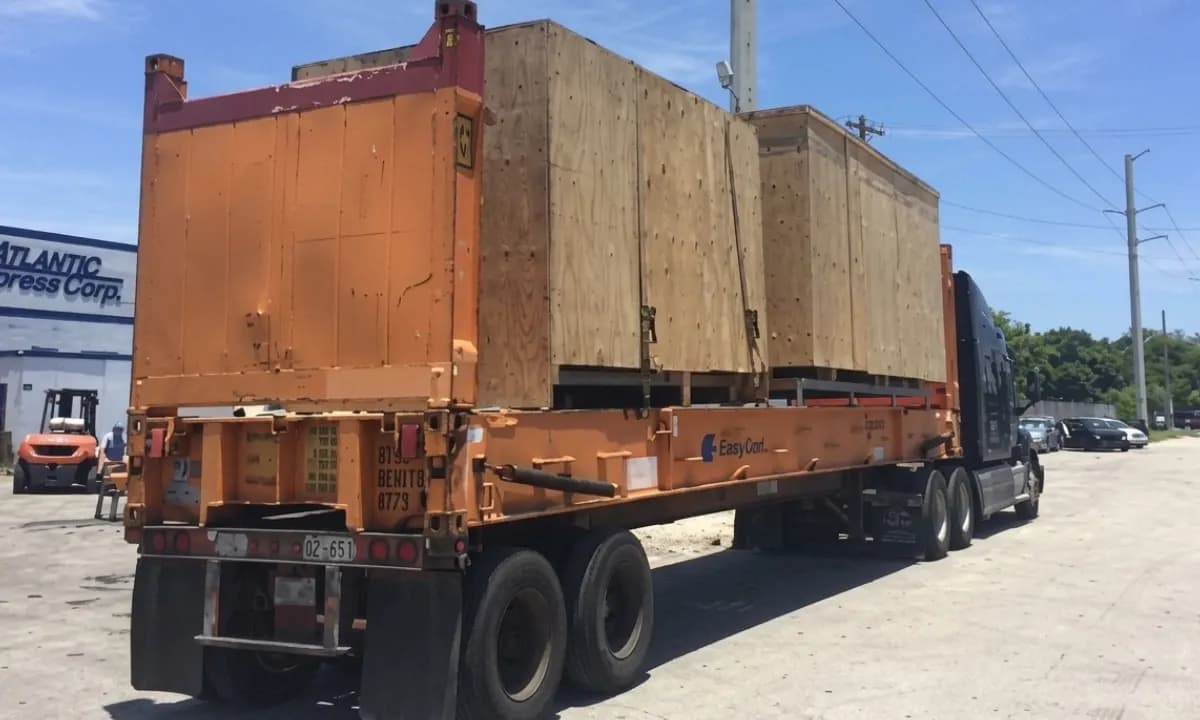 Two timber crates strapped down on a flat rack trailer.