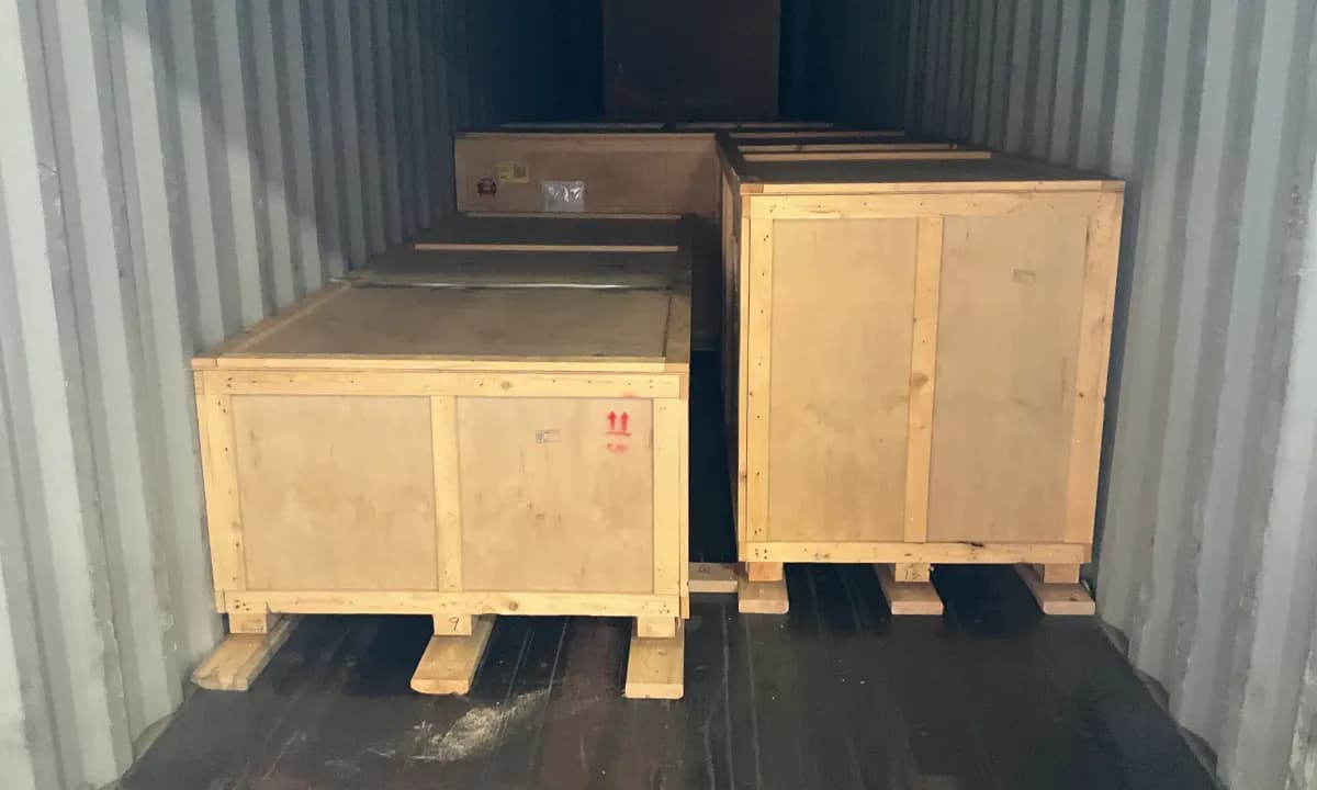 Crated cargo on pallets loaded inside a shipping container.