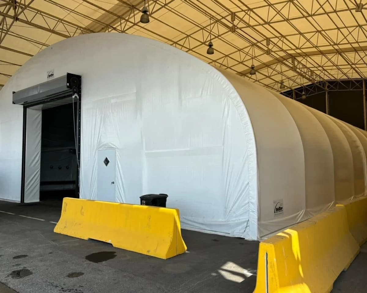 Heavy equipment enclosed in fumigation tent.